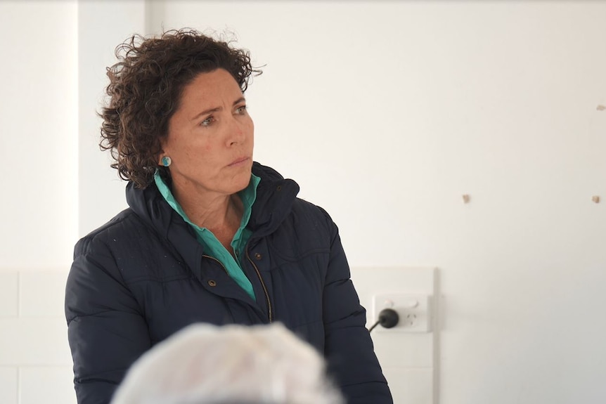 Woman listens at a community meeting