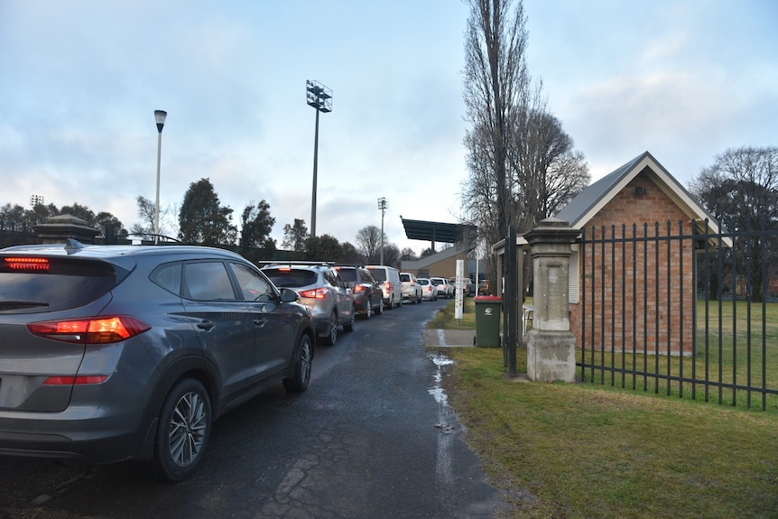 Cars line up outside a drive-through COVID-19 testing site.