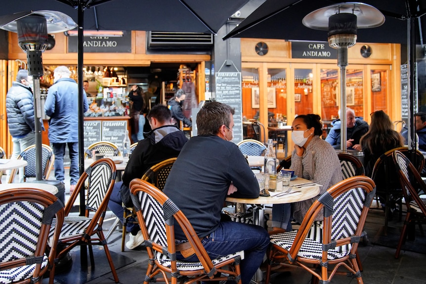 Diners wear protective face masks at a cafe in Melbourne CBD