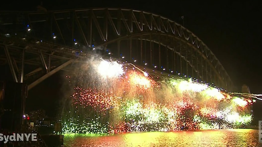 Fireworks waterfall off the side of the Sydney Harbour bridge for the early fireworks.