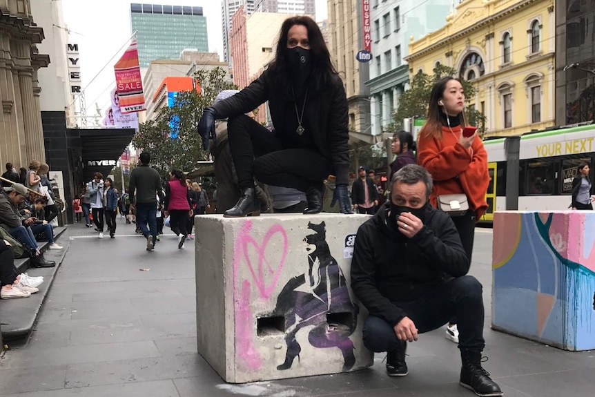 Street artists Cit Cat stand near their painted security bollard in Bourke Street mall.