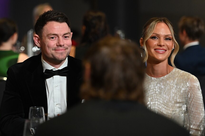 Lachie Neale and Jules Neale smile while sitting at their table during the Brownlow Medal count