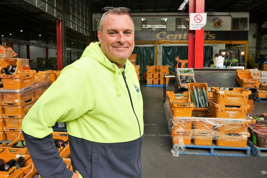 Man standing with vegetable crates.