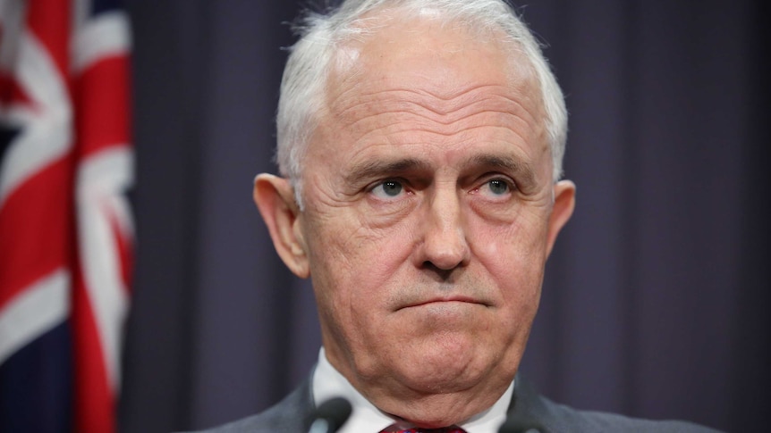 Malcolm Turnbull, with a furrowed brow and down-turned mouth, looks towards the journalists at a press conference.