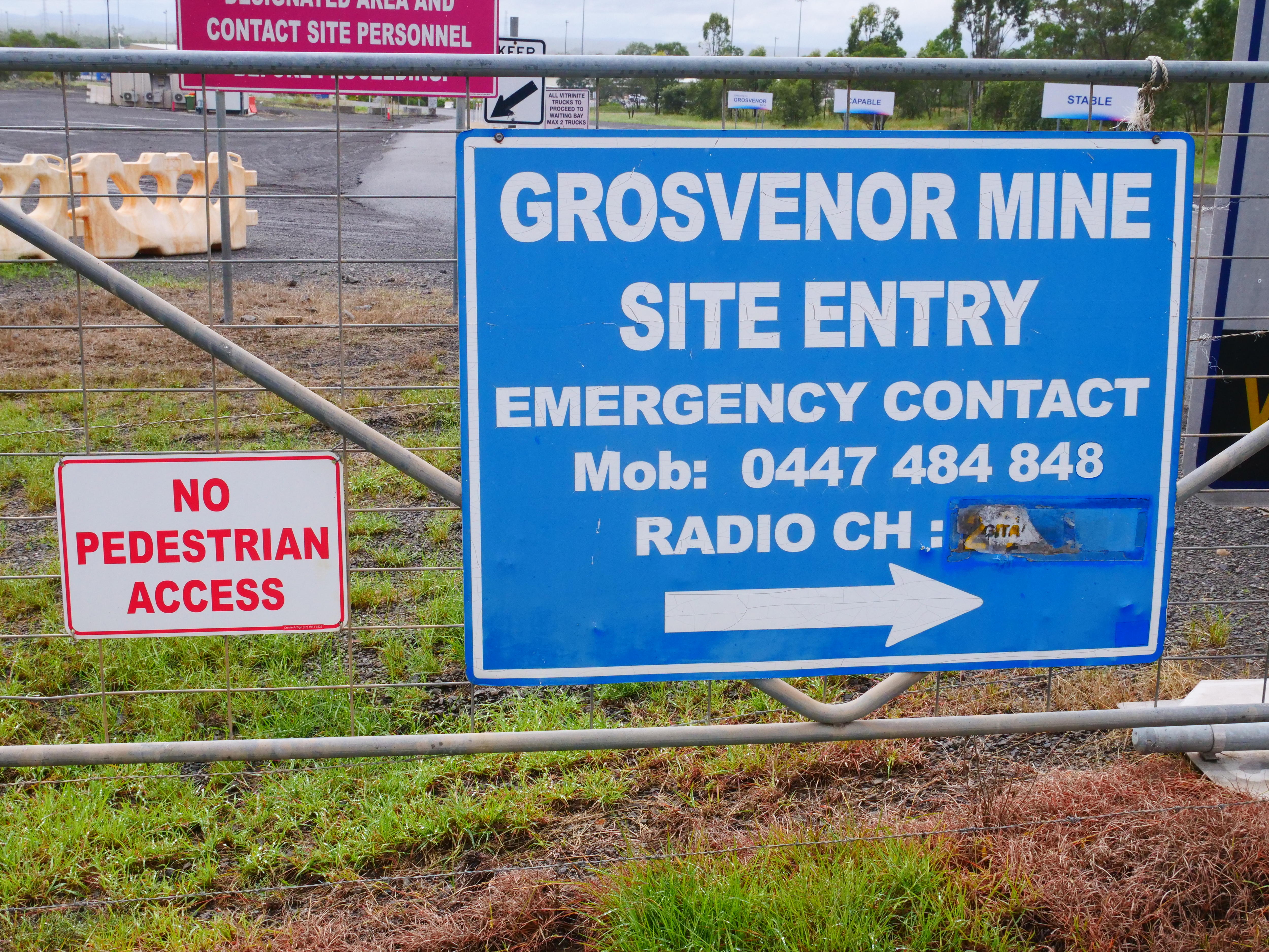 Un letrero azul, que lee 'Grosseor Mine' y enumera los canales UHF, fijados a una puerta de acero en una entrada de mina. 