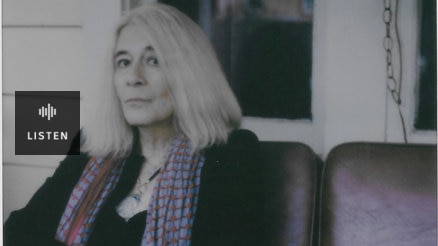 A colour faded inmage of a woman sitting in a chair on a verandah. Has Audio.