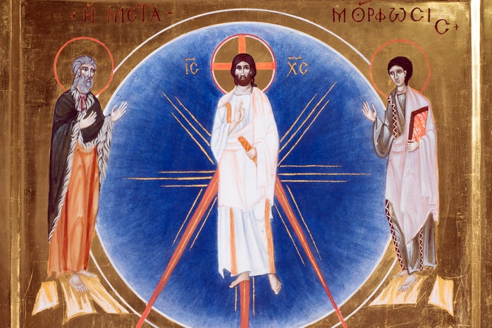 An image of an icon showing Jesus Christ on a luminescent blue background with saints on a gold background.