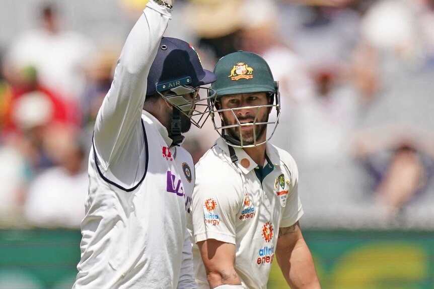 India's Rishabh Pant, raising his hand, and Australian Matthew Wade exchange words on day three of the second Test at the MCG.