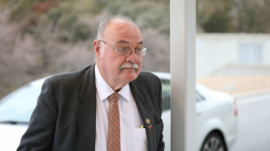 Warren Entsch, dressed in suit and tie, walks into Parliament