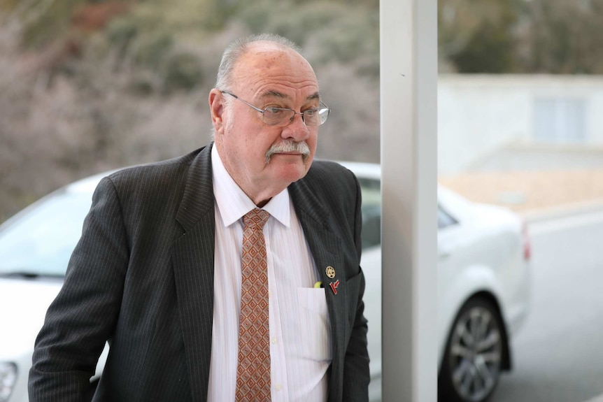 Warren Entsch, dressed in suit and tie, walks into Parliament