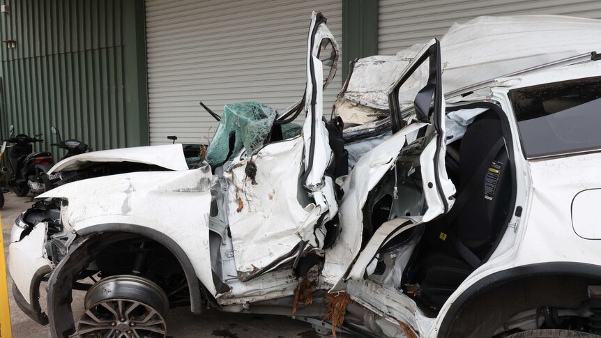 The wreckage of a car involved in a fatal crash inside a towing yard.