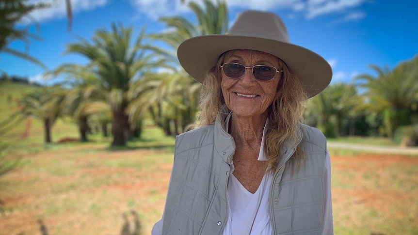 Gabrielle Morley standing in field with palm trees in background