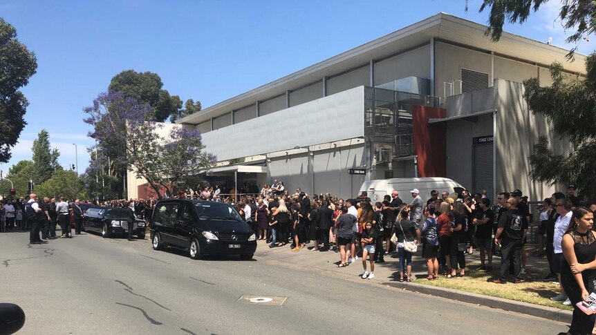 Hundreds of people lining the streets at a funeral in Victoria