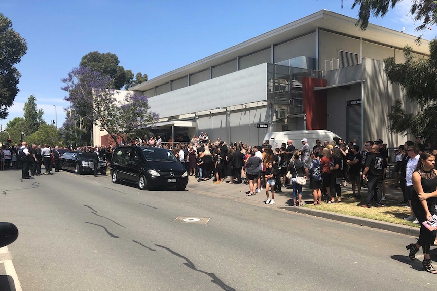 Hundreds of people lining the streets at a funeral in Victoria