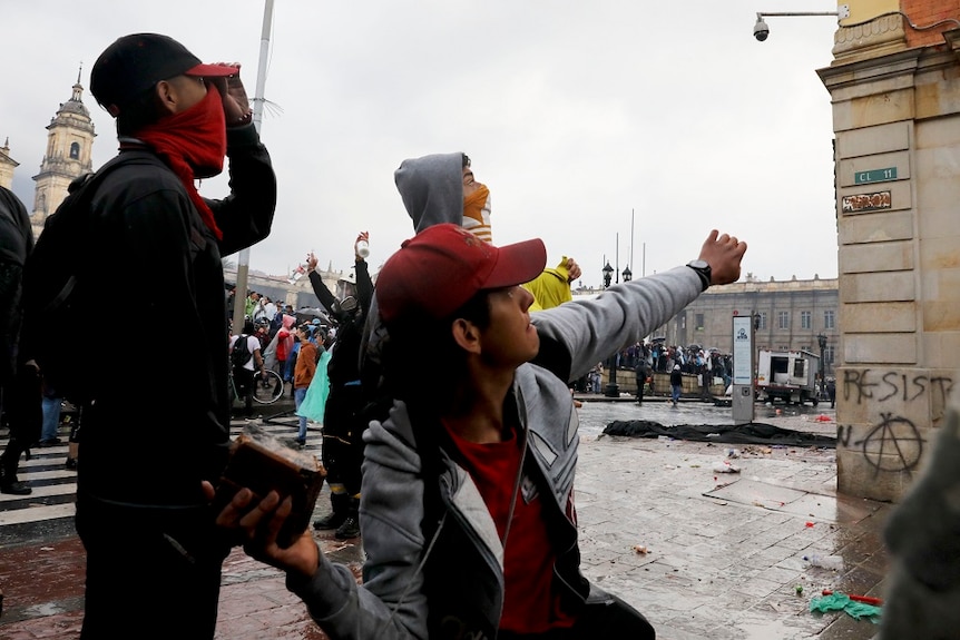 Protesters throwing bricks.