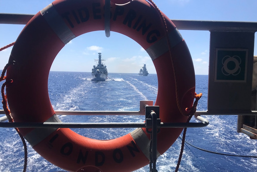 A view of the HMS Richmond at sea from the back of another British vessel.