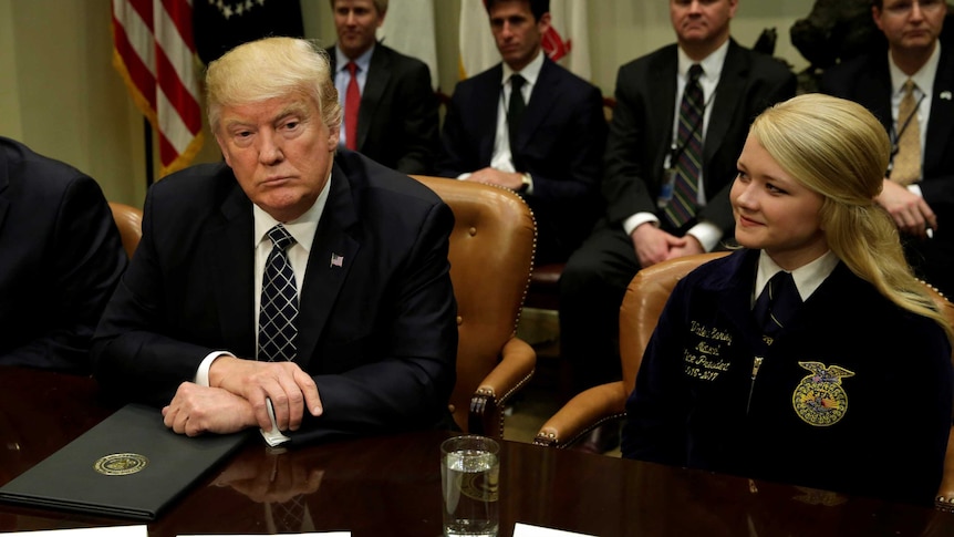 US President Donald Trump listens to the media's questions during a roundtable discussion.