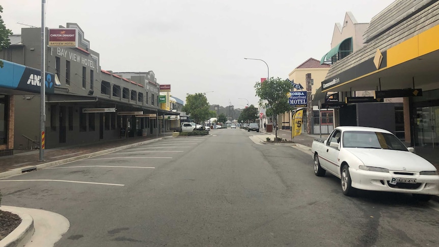 An empty street with a smoky haze hanging overhead.