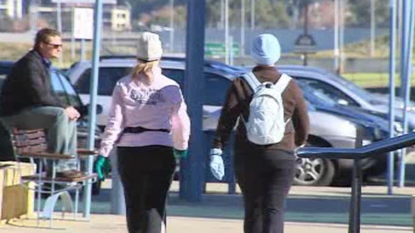 Two walkers rugged up against the cold in Perth, gloves, hats etc