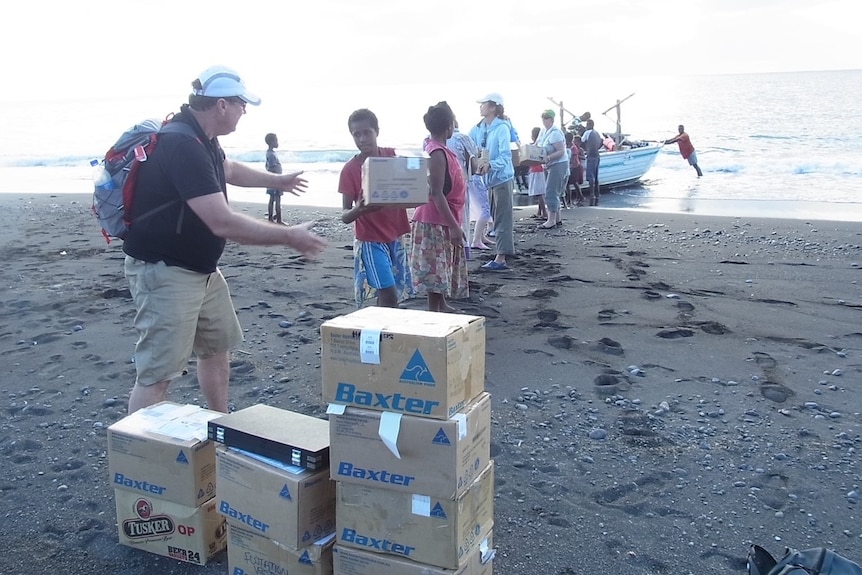 boxes are passed from boat to shore, person to person  