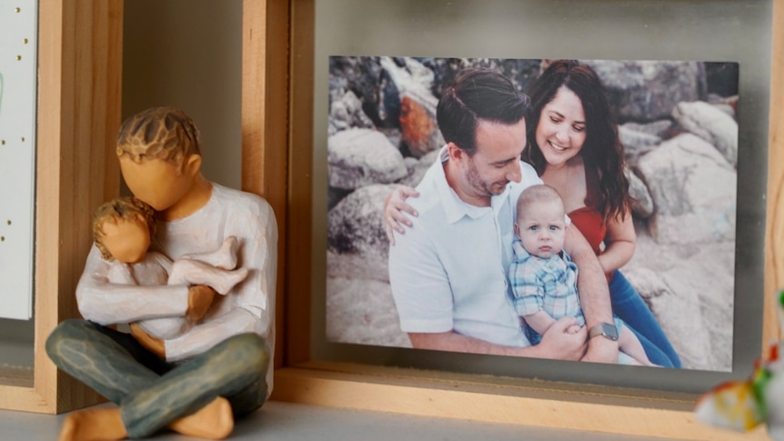 A framed photo of a baby and his parents