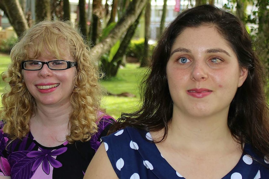 Two women look at the camera.