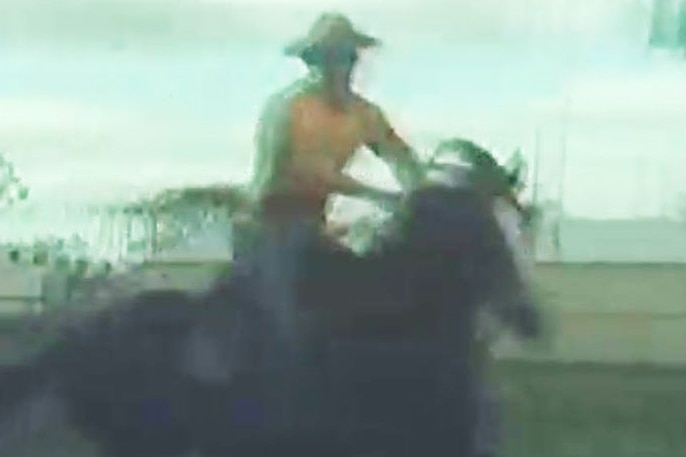 A still from a video of a man riding a horse.