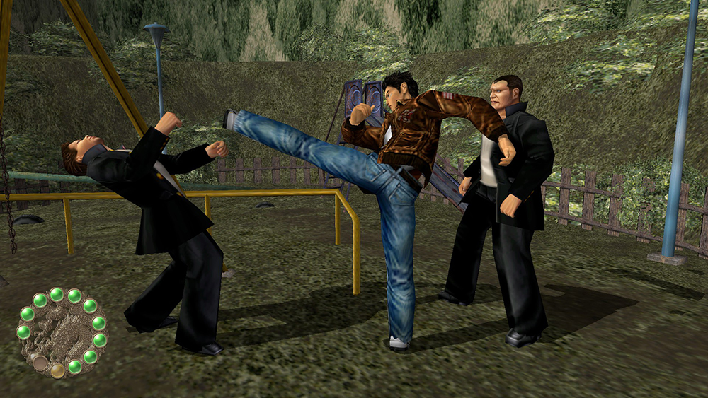 In a scene from a video game, a Japanese man in jeans and brown jacket kicks and fights two me in black in park-like setting.