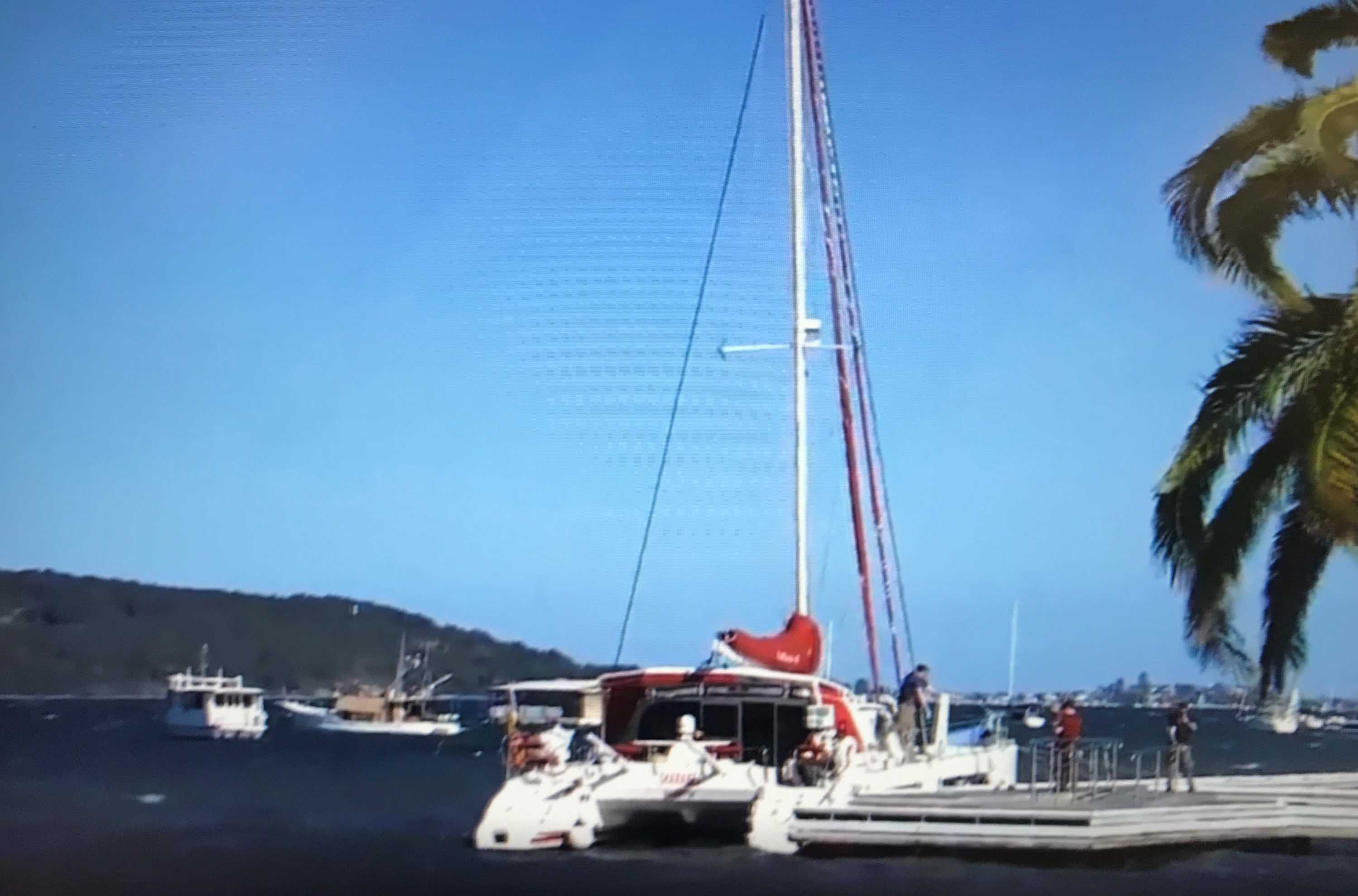Twin-hulled yacht moored at a jetty.