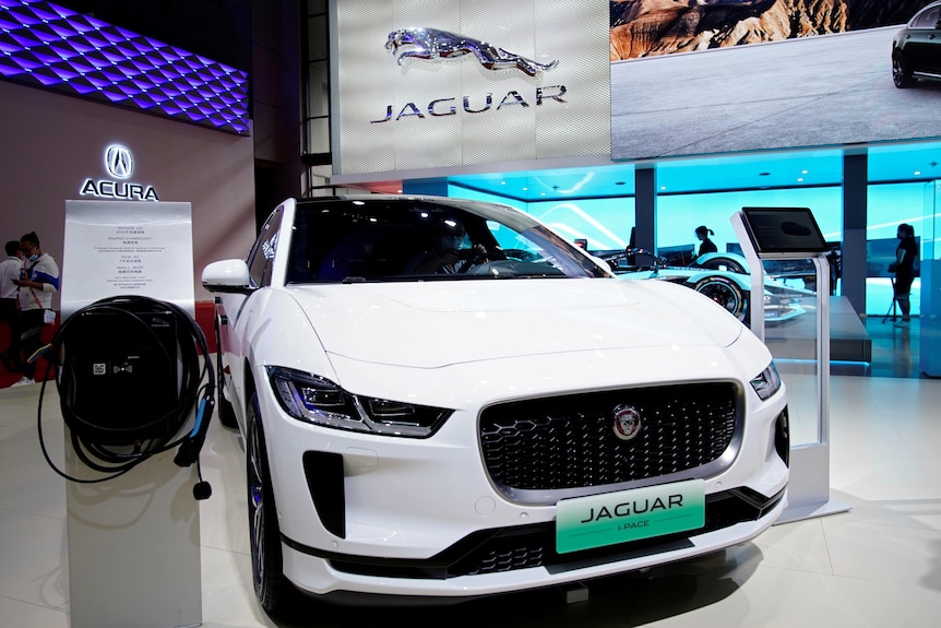 A white Jaguar I-Pace electric car on display in a show room.