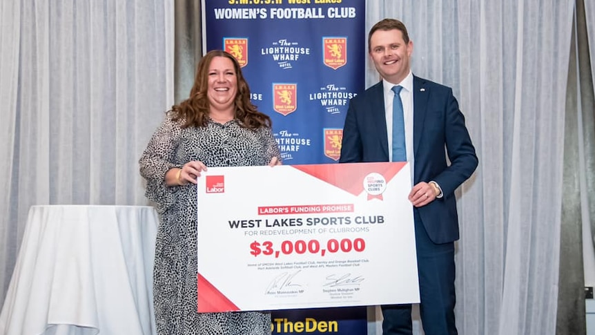 Treasurer Stephen Mullighan holding a 3 million dollar cheque for the West Lakes Sports Club