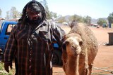 Docker River local Lyle Kenny poses for photos with his pet camel Lasseter