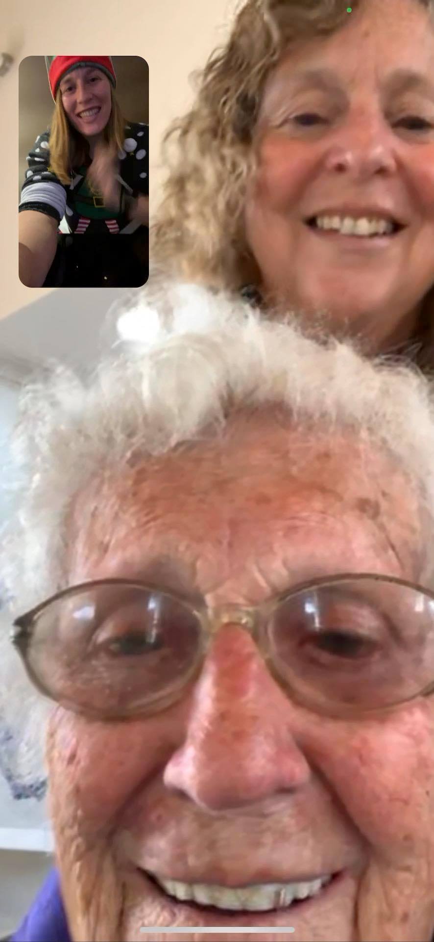 A young woman on a video call with two older women.