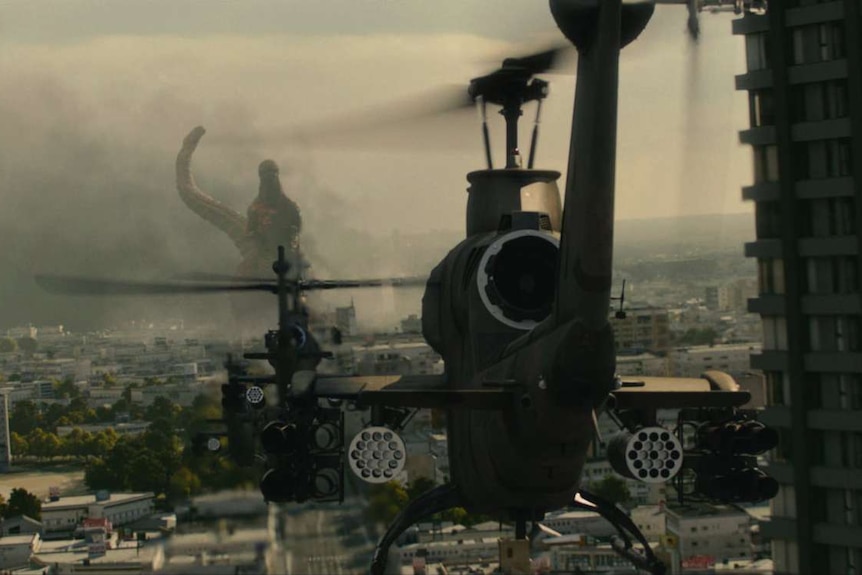 A helicopter heads towards Godzilla as it makes a path of destruction through Tokyo.