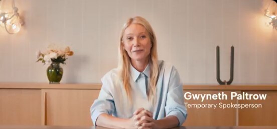 Gwyneth Paltrow in a light room with a blue shirt sat at a table 