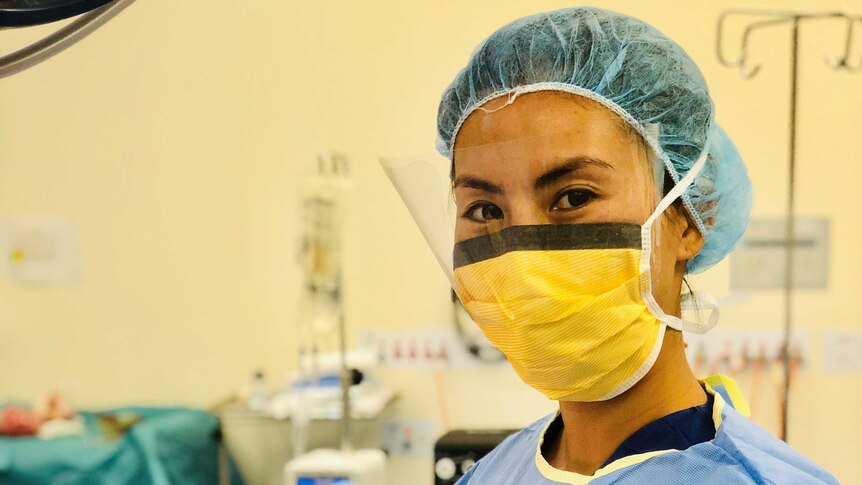 Yumiko Kadota wears a surgical mask and scrubs