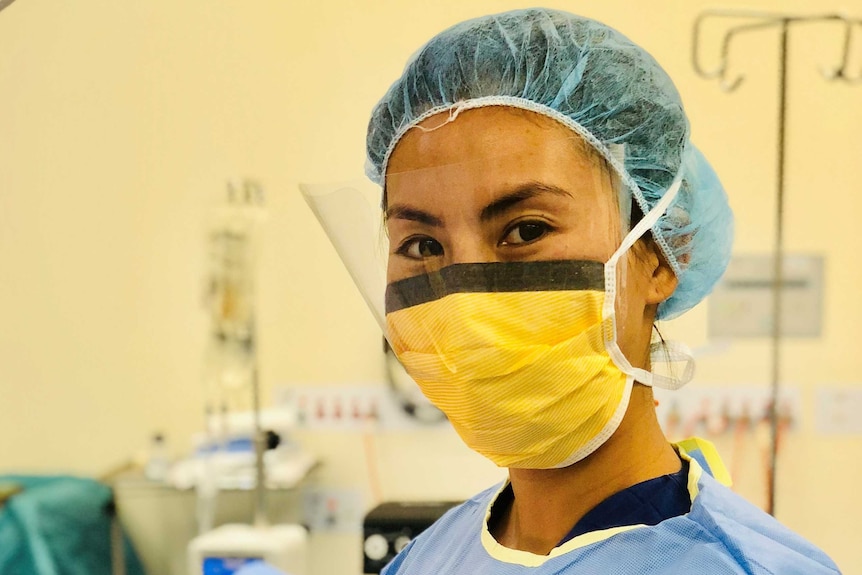 Yumiko Kadota wears a surgical mask and scrubs