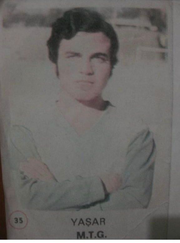 A man wearing a pale jumper has his photo taken