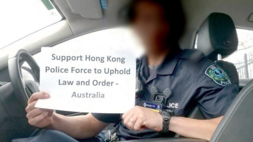 A photo of a uniformed police officer with a sign: "Support Hong Kong Police Force to Uphold Law and Order - Australia"