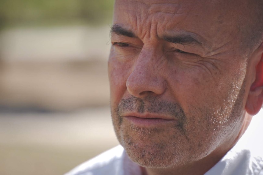 a close-up photo of a man looking off frame