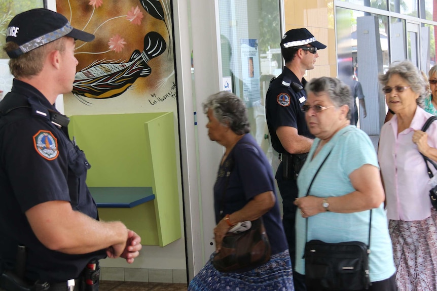 Former Retta Dixon Home residents enter the NT Police station on Darwin's Mitchell Street.