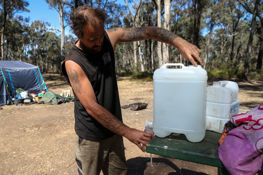 A man pours water from a large plastic jug.