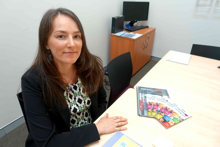 A woman in an office with Legal Aid pamphlets.