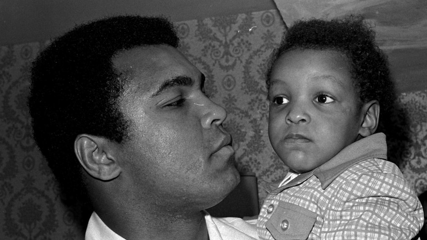 Muhammad Ali holding his 2 year old son  Muhammad Ali in 1975.