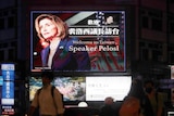 周二，在台湾台北，人们走过欢迎美国众议院议长佩洛西的广告牌。