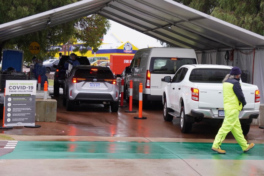 A queue of cars at a tented drive-through testing clinic.