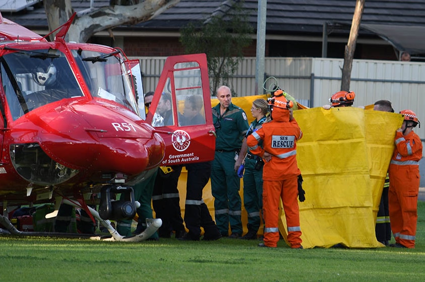 Emergency service personnel stand around medical helicopter