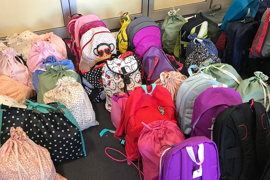 Emergency bags for families fleeing domestic violence, lined up and ready for distribution to Tasmanian collection points.