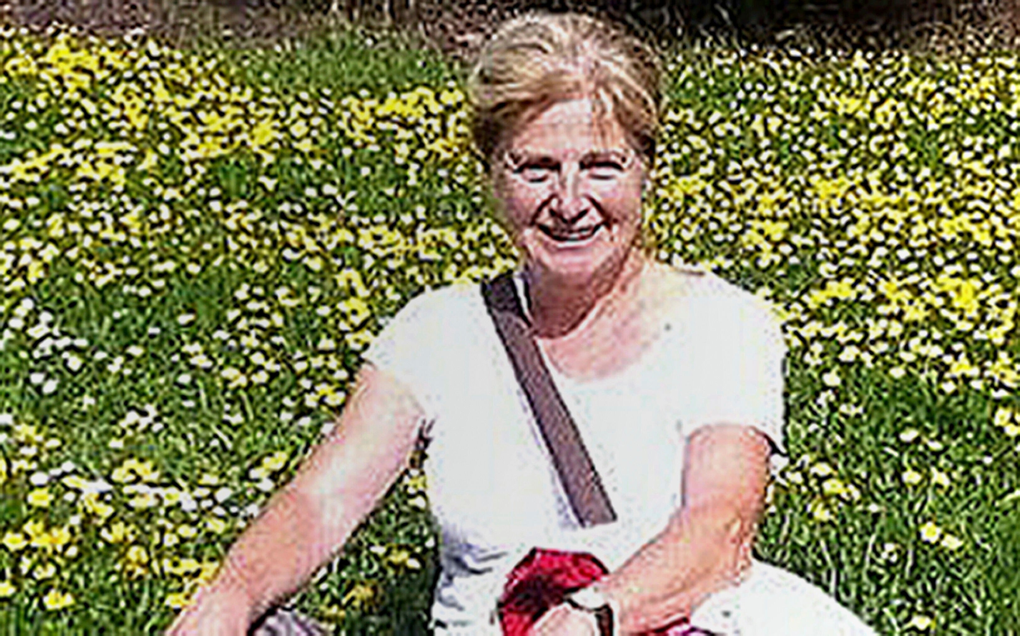 A grainy photo of a woman in a field of yellow flowers 