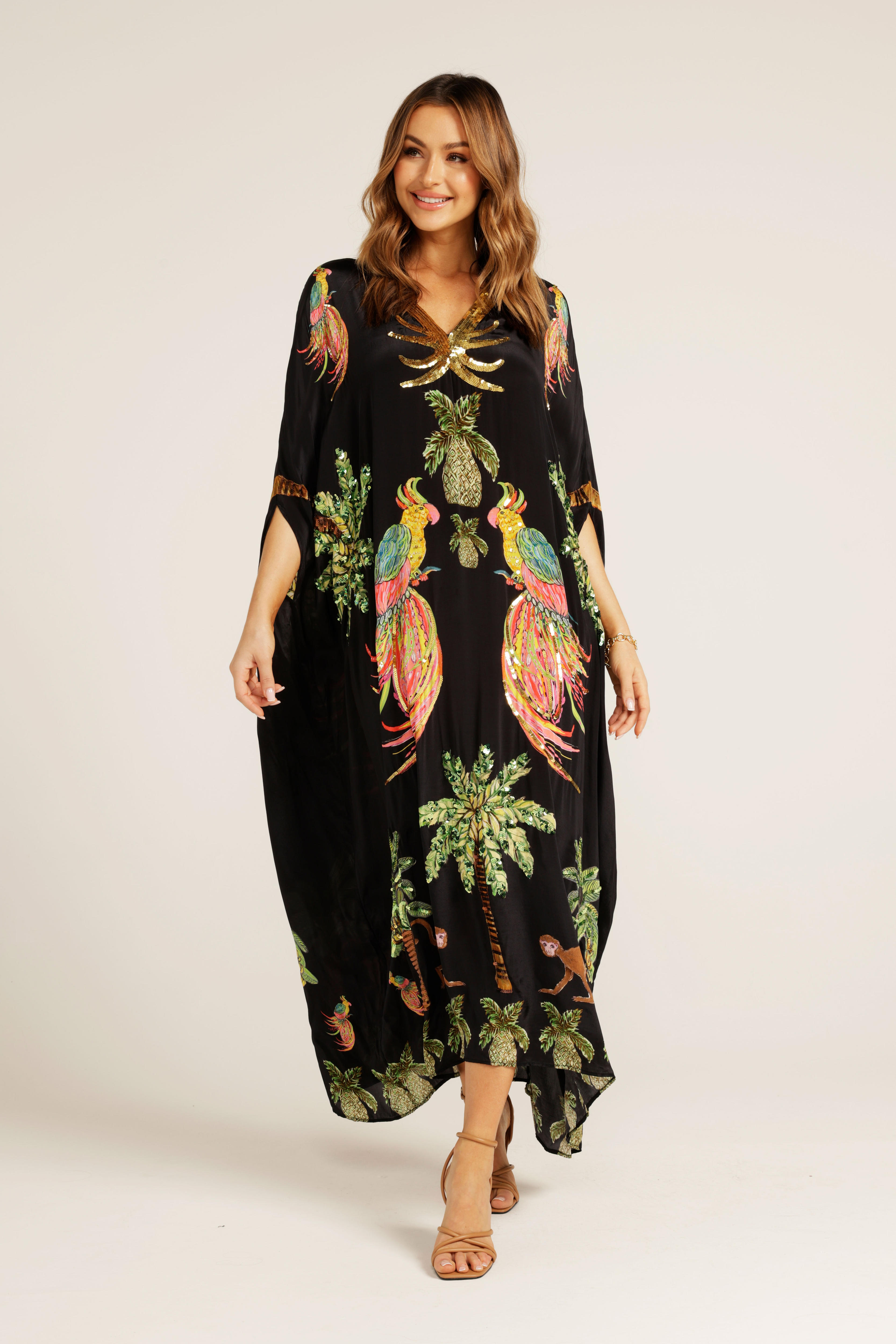 A woman wearing a kaftan with a tropical sequined design. 
